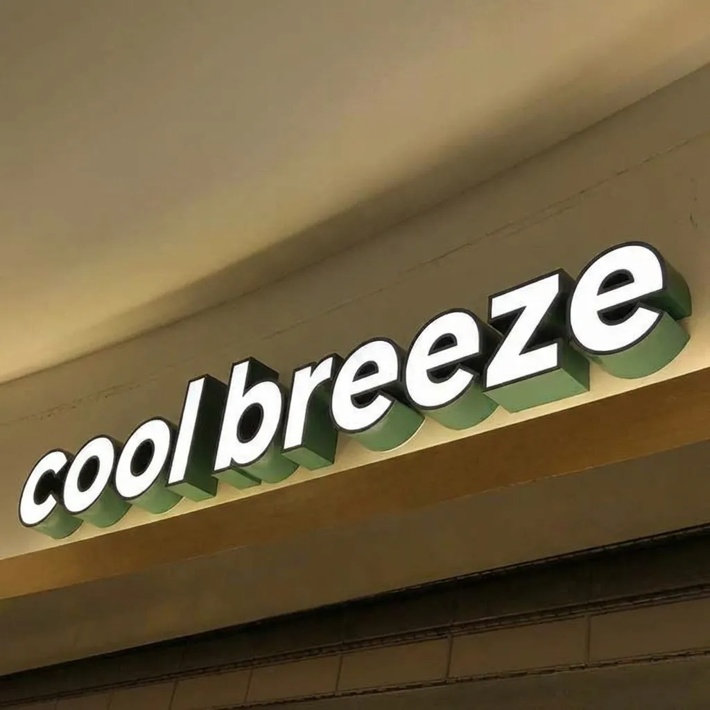 曲面の天井の下にある光る立体文字のサイン。左は hotwind、右は cool breeze で、白い正面と緑の側面は同じです (編集後)