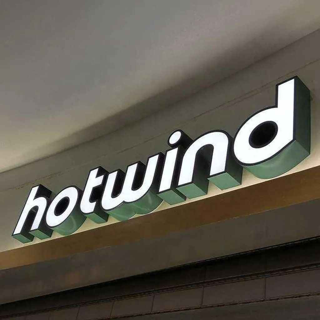 曲面の天井の下にある光る立体文字のサイン。左は hotwind、右は cool breeze で、白い正面と緑の側面は同じです (元の写真)