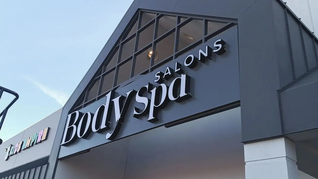 濃い色の外壁に白い大きな文字のサイン。左は Body spa、右は同じ書体の Body Oasis に変わっています (元の写真)